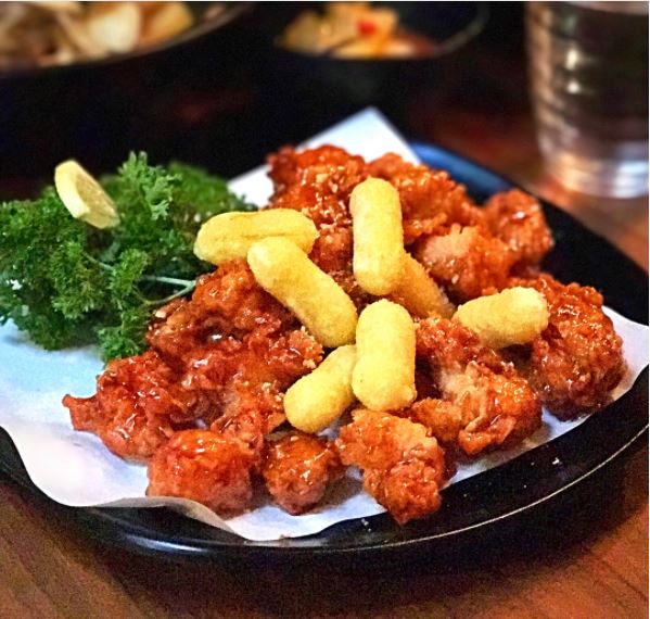 Image of spicy dakgangjung, which is boneless fried chicken and fried tteokbokki coated with a sweet, tangy and spicy sauce at Twins Korean Restaurant