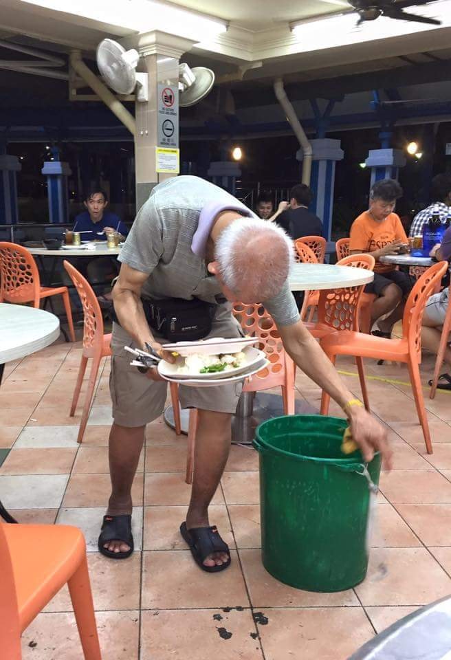 Hunchbacked elderly man seen clearing plates despite tray-return rule already being implemented
