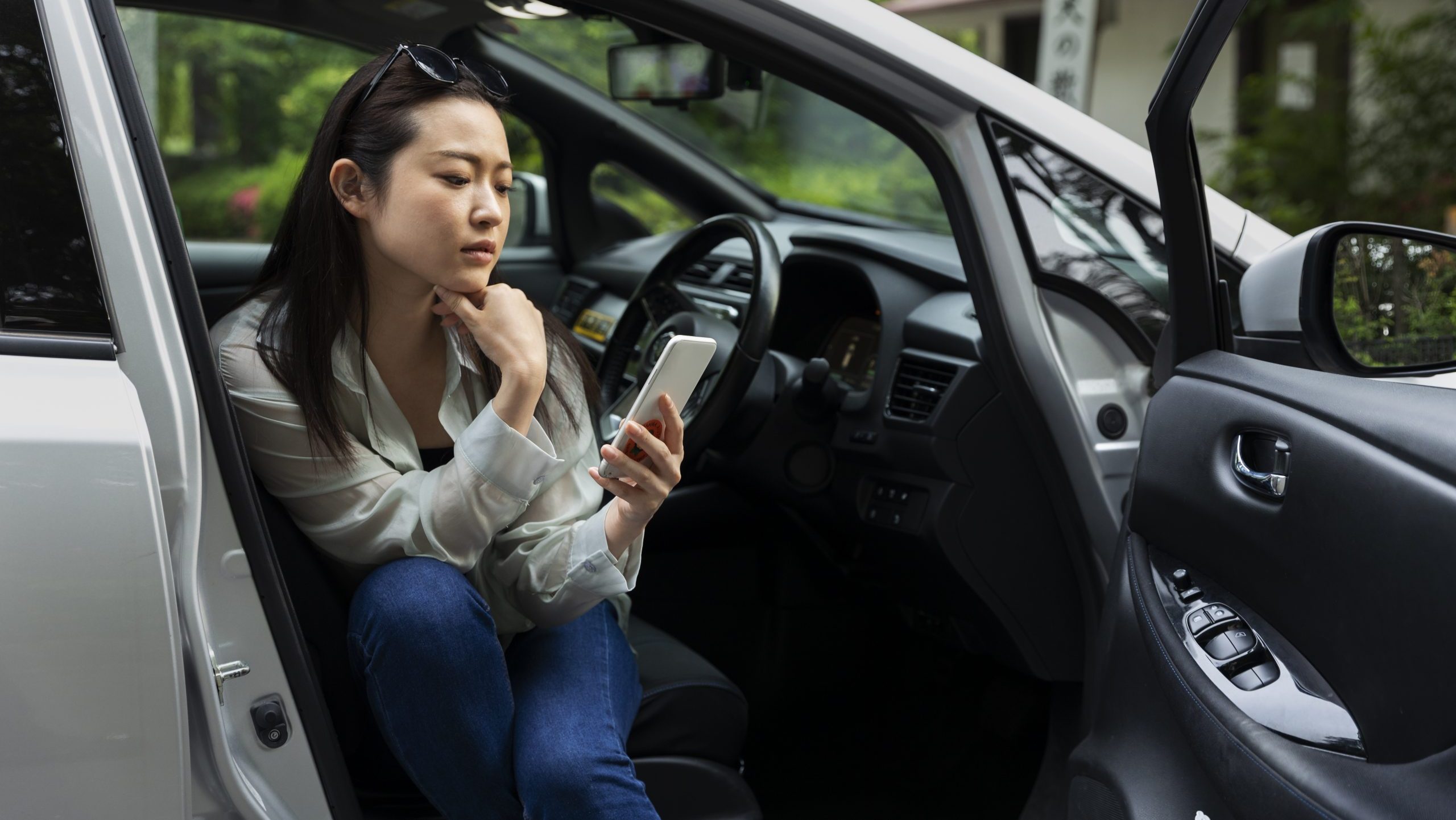 Woman using smartphone in car