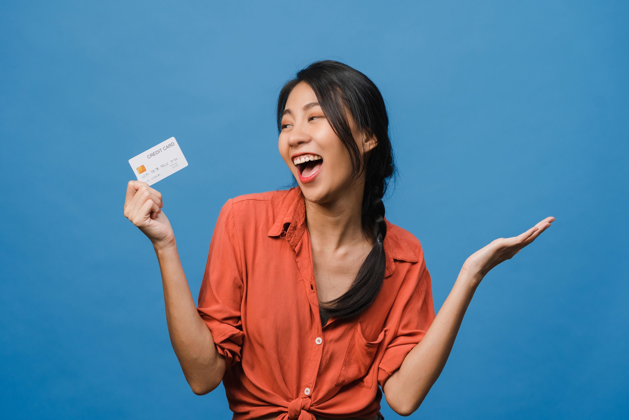 Happy Asian woman holding a credit card.