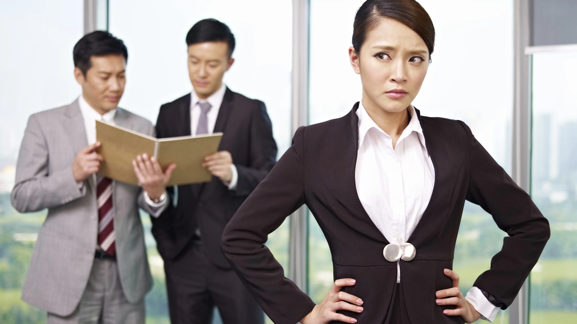 Woman looking at her two bosses talking.