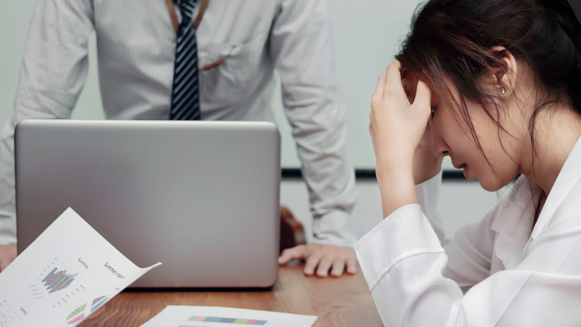 Stressed exhausted young Asian business woman suffering from severe depression between meeting in office.