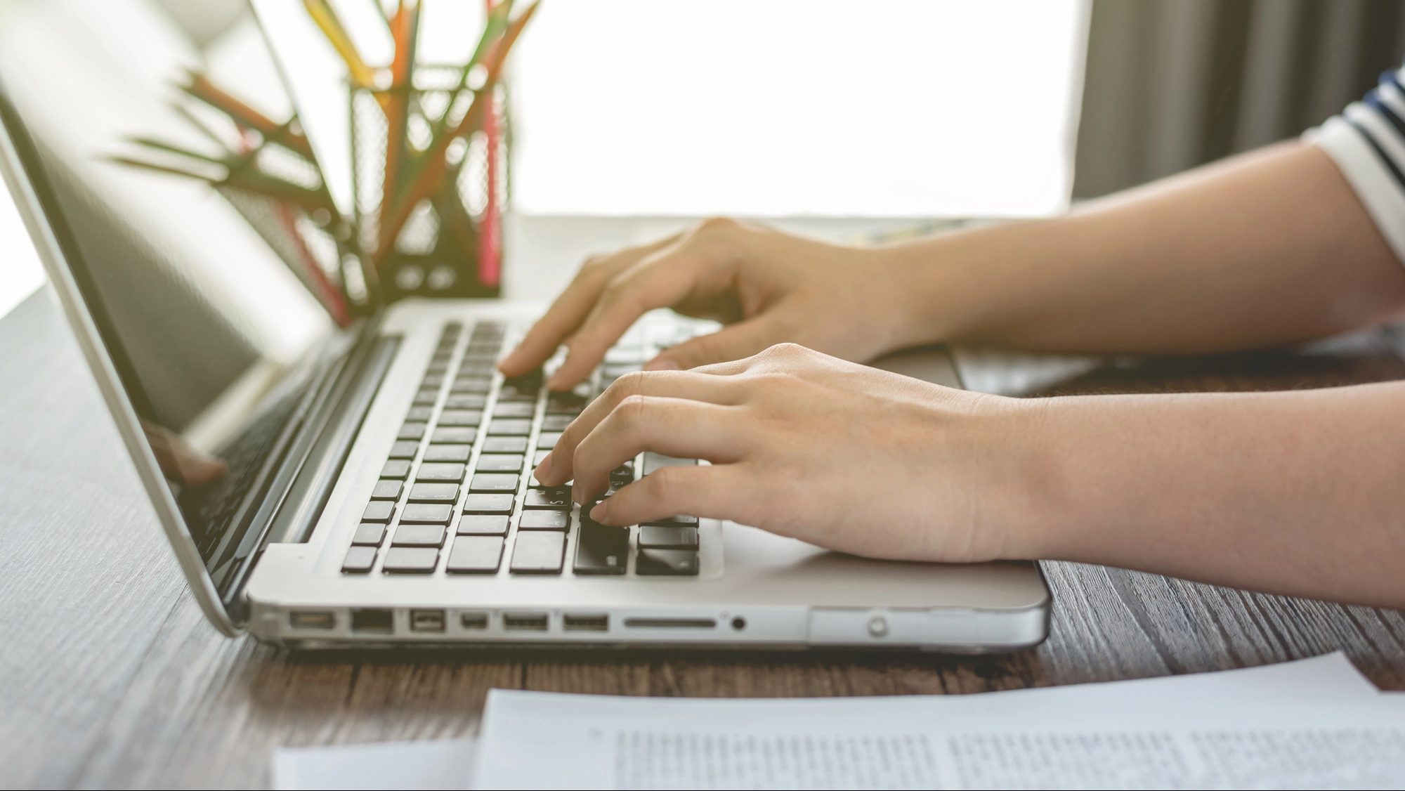 Hand typing on laptop.