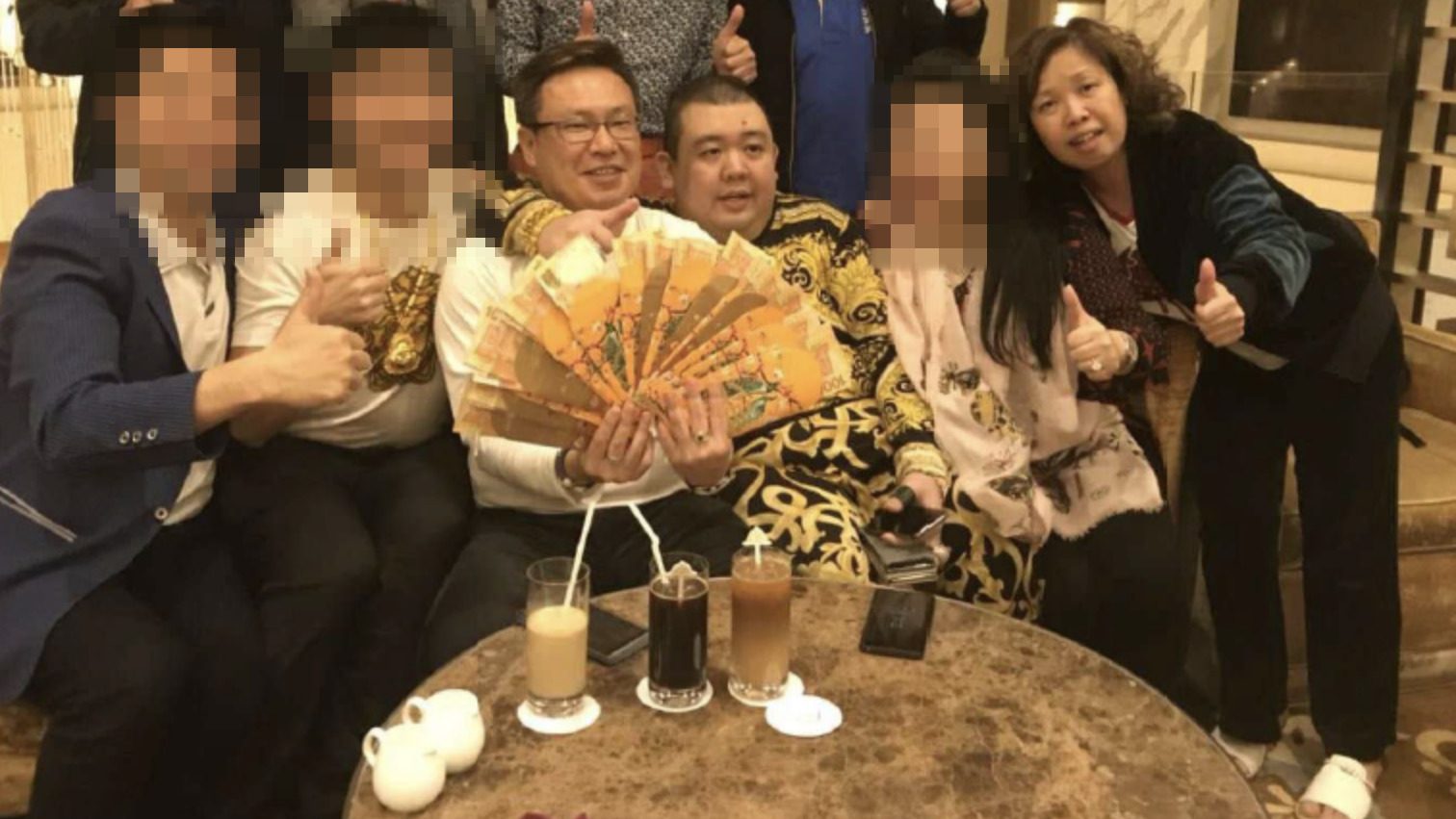 Singaporean couple Wan Hoe Keet (left) and his wife Sally Ho with SureWin4U scheme co-founder Peter Ong in a 2018 meeting in Macau.