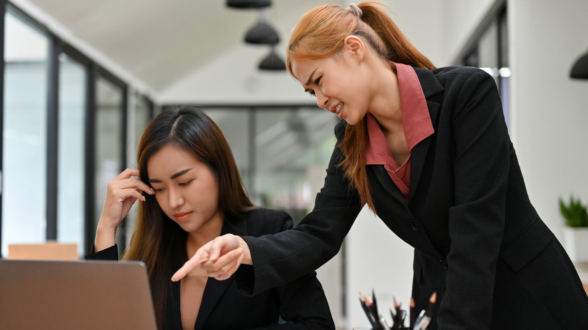 An angry female boss is complaining to her assistant about her work performance in the office. A stressed female employee gets a complaint from her manager.