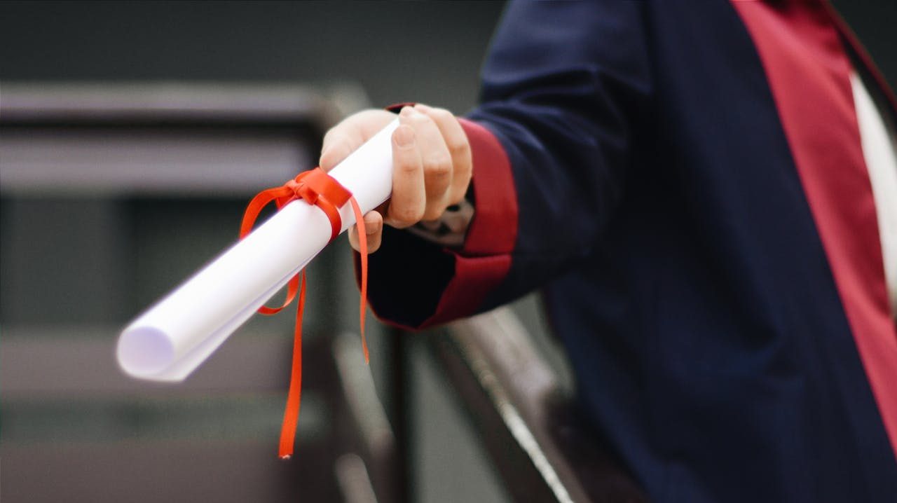 A graduate holding a diploma