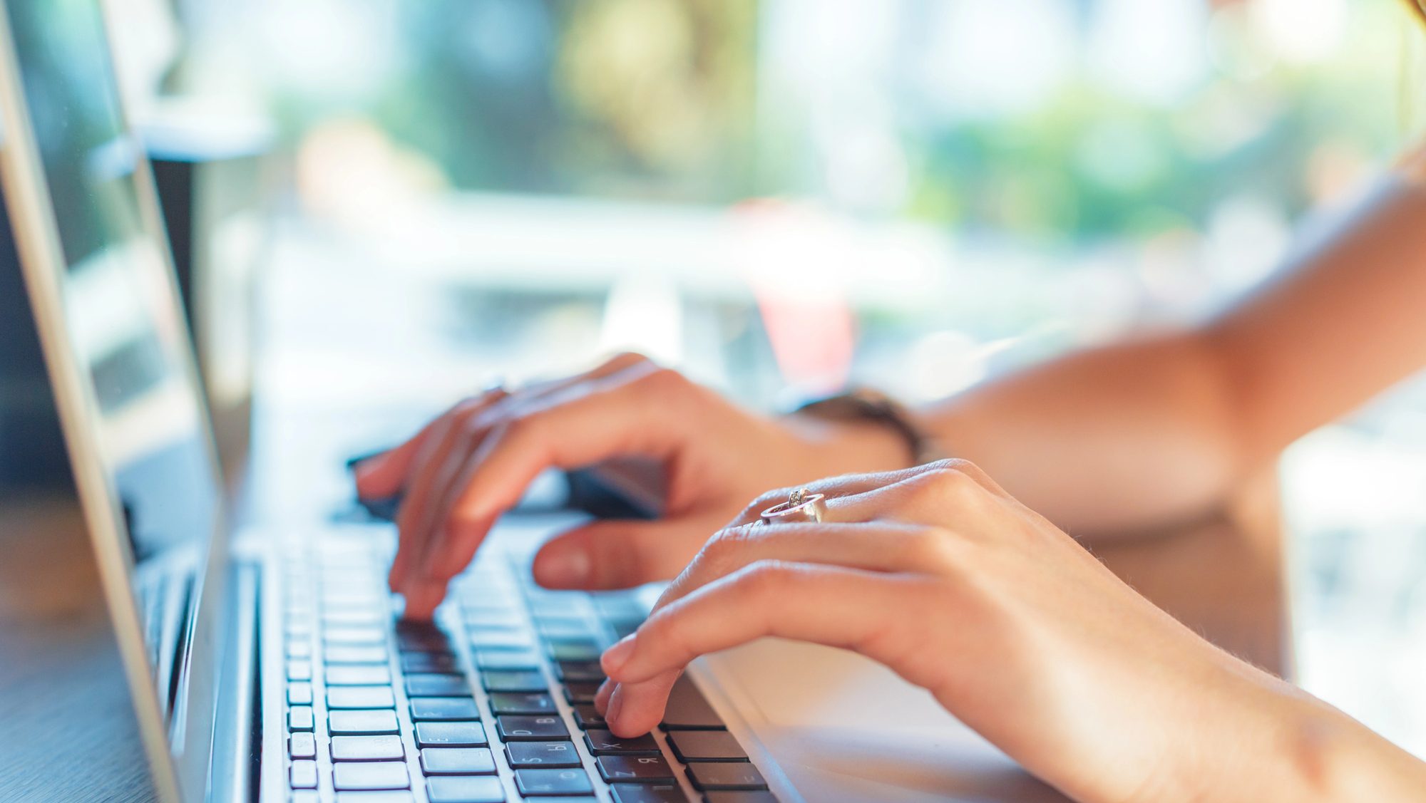 Hand typing on a laptop.