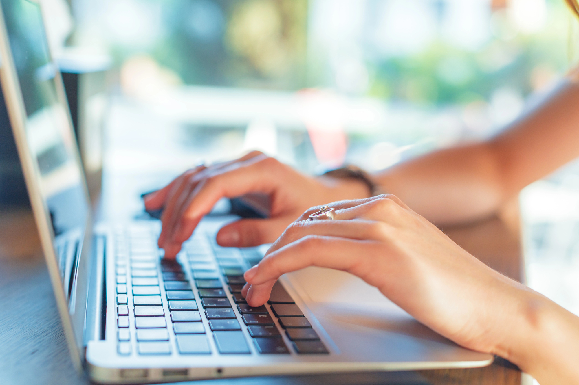 Hand typing on a laptop.