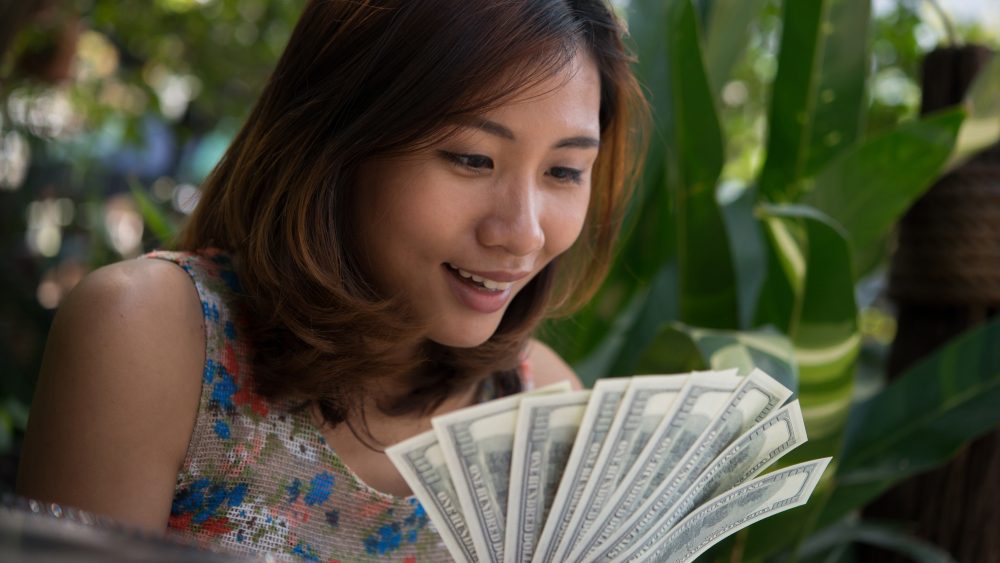 Woman holding a fan of cash.