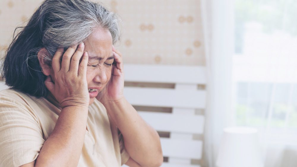 Asian senior woman holding her head