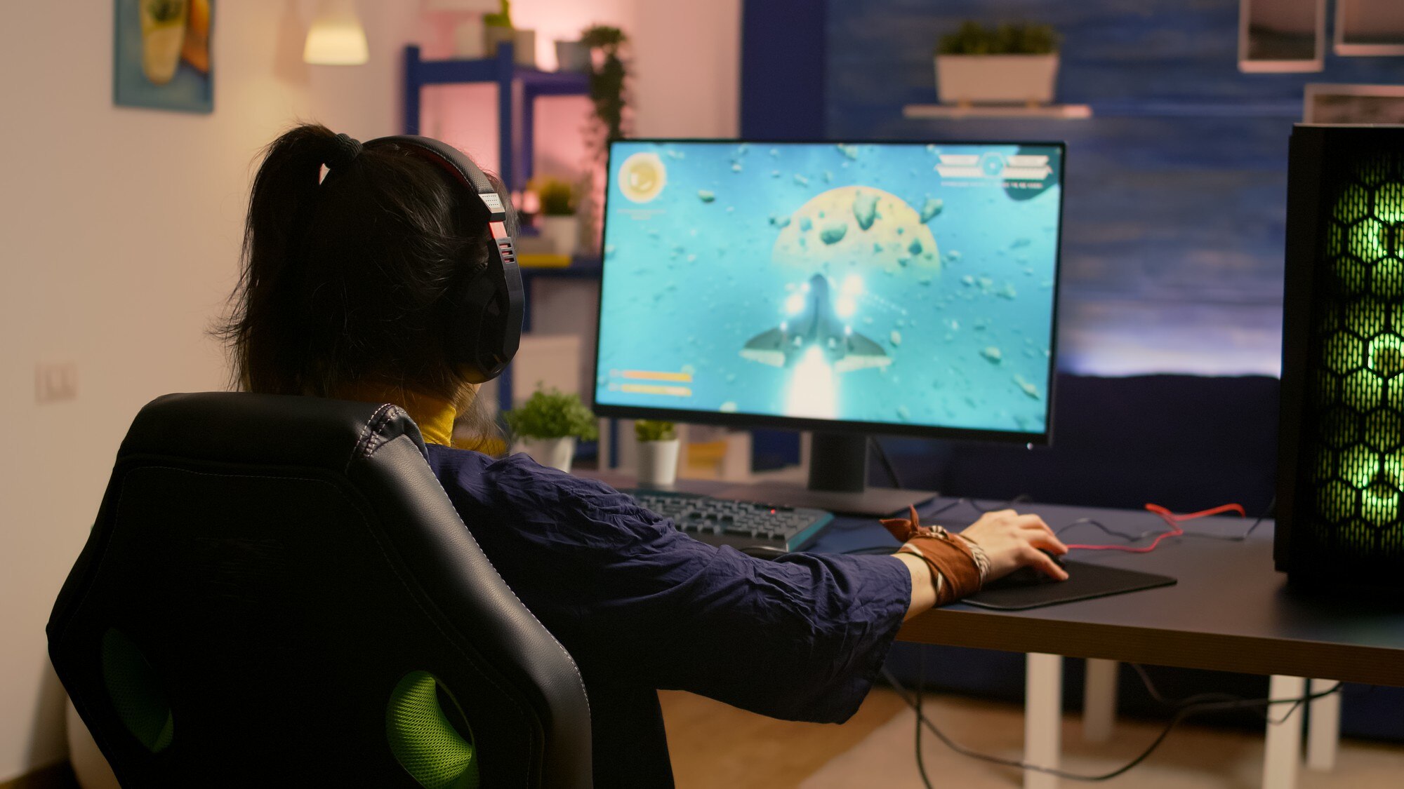 gamer sitting on gaming chair at desk and playing space shooter video games