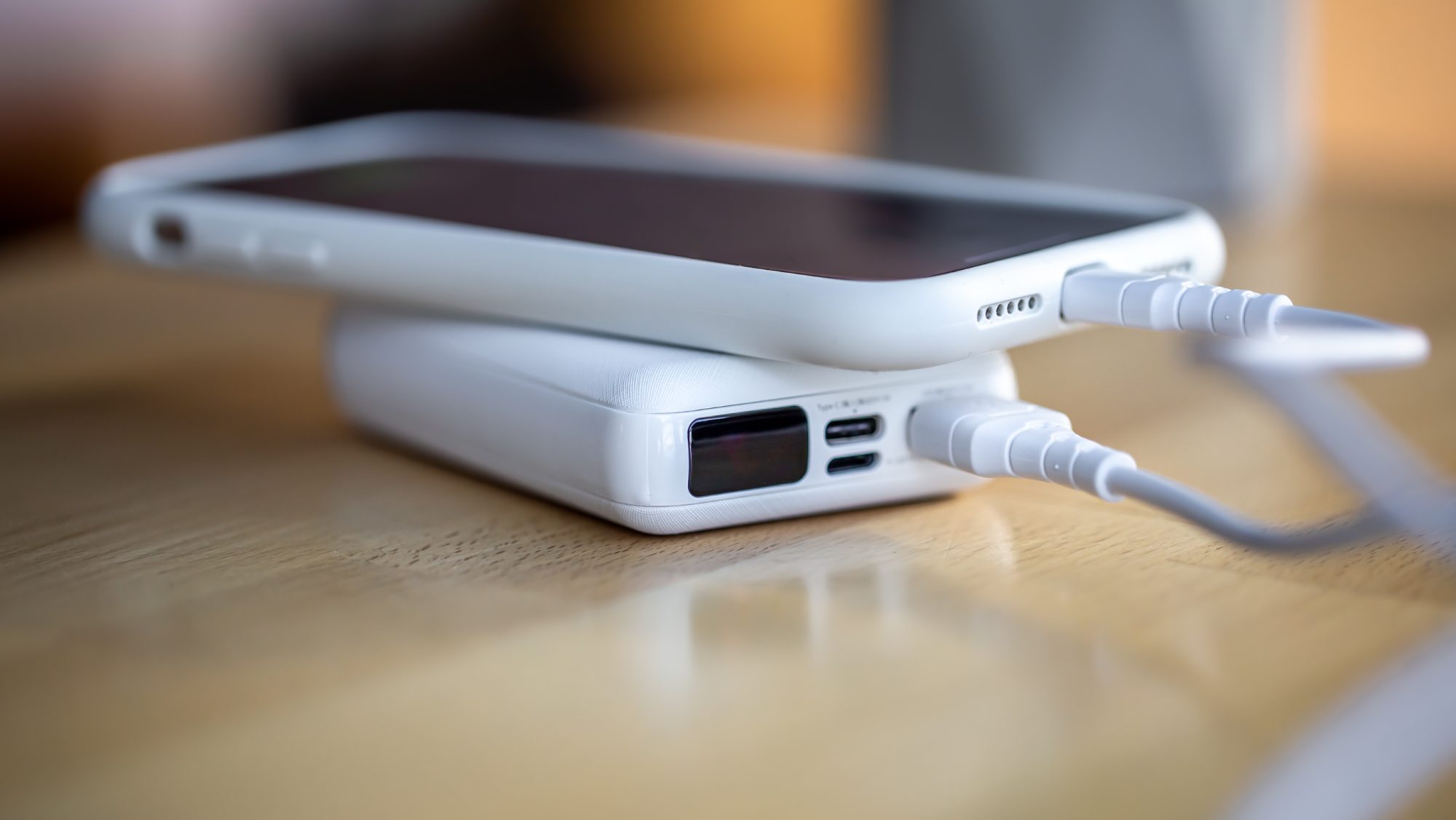 White phone charging through a white power bank