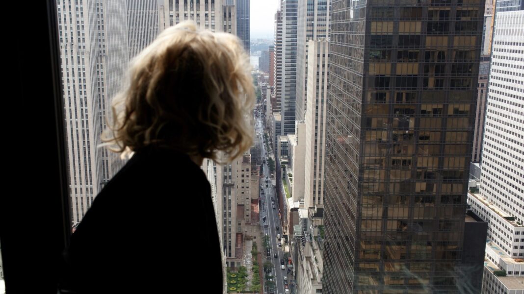 A woman looking out at the buildings in the city.