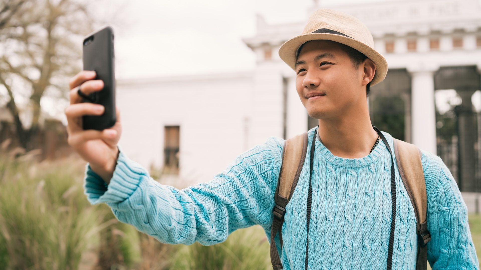 asian tourist taking selfie with mobile phone e1757819012781
