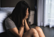 When even RM7,000 a month isn’t good enough for one Malaysian woman’s parents, who kept pressuring her to work in Singapore for more money A woman in a gray shirt sits on the floor, leaning against a bed, with her face buried in her hands, while the room is dimly lit, conveying a sense of sadness and distress